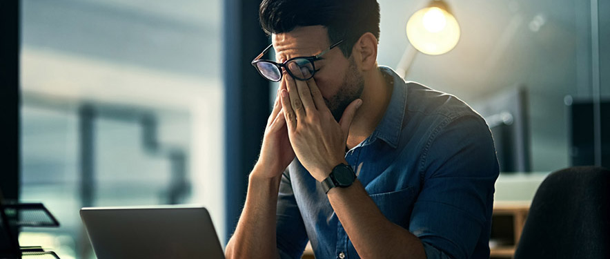 man stressing out in front of his laptop